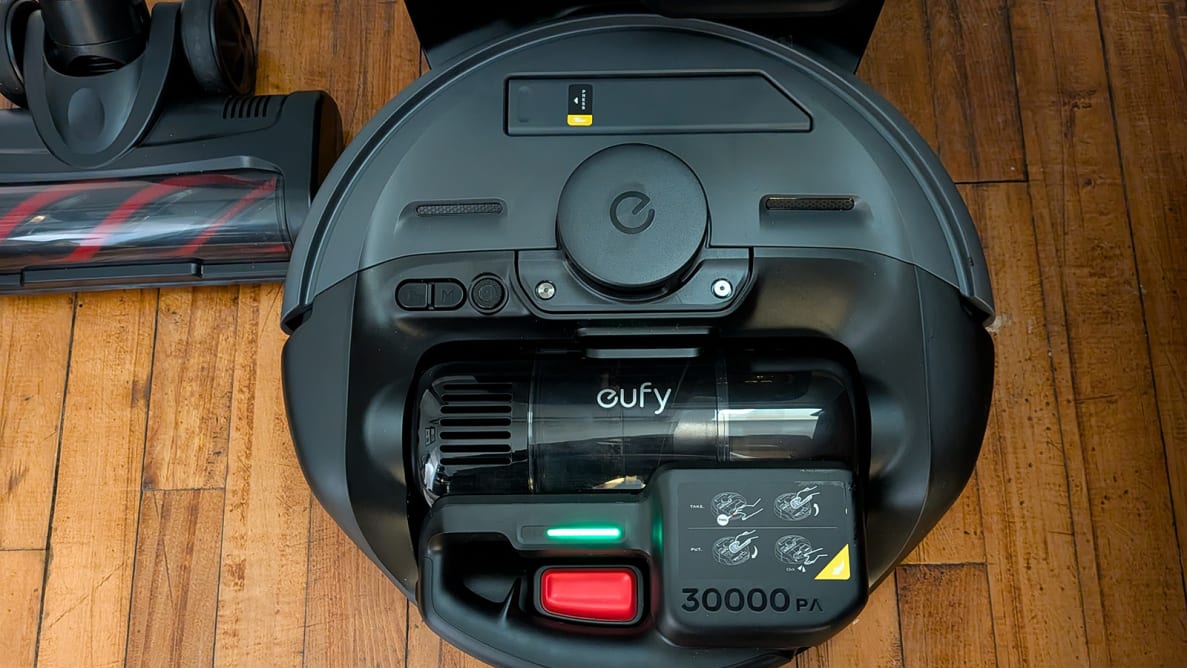 A black robot vacuum on a wood floor