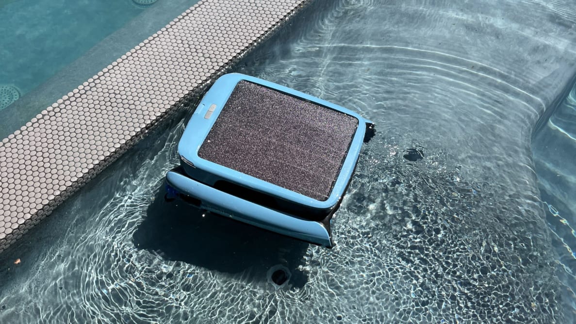A blue square pool robot sits on top of the water