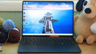 An opened Microsoft Surface Laptop 7th Edition on a desk next to a stuffed animal and balls of yarn.