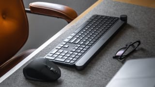 A picture of a wireless keyboard and mouse on a desk mat